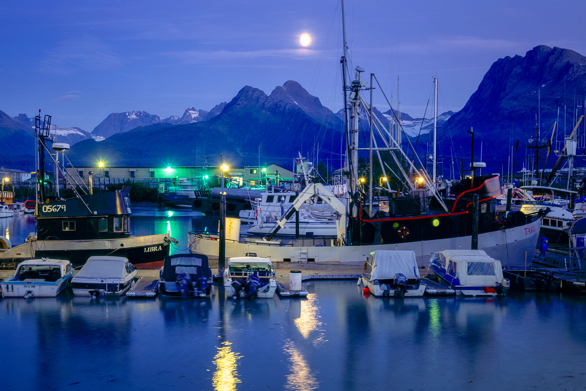 In the enchanting moments of blue hour, "Moonrise over Seward Harbor" transports you to the tranquil harbor of Seward, Alaska...