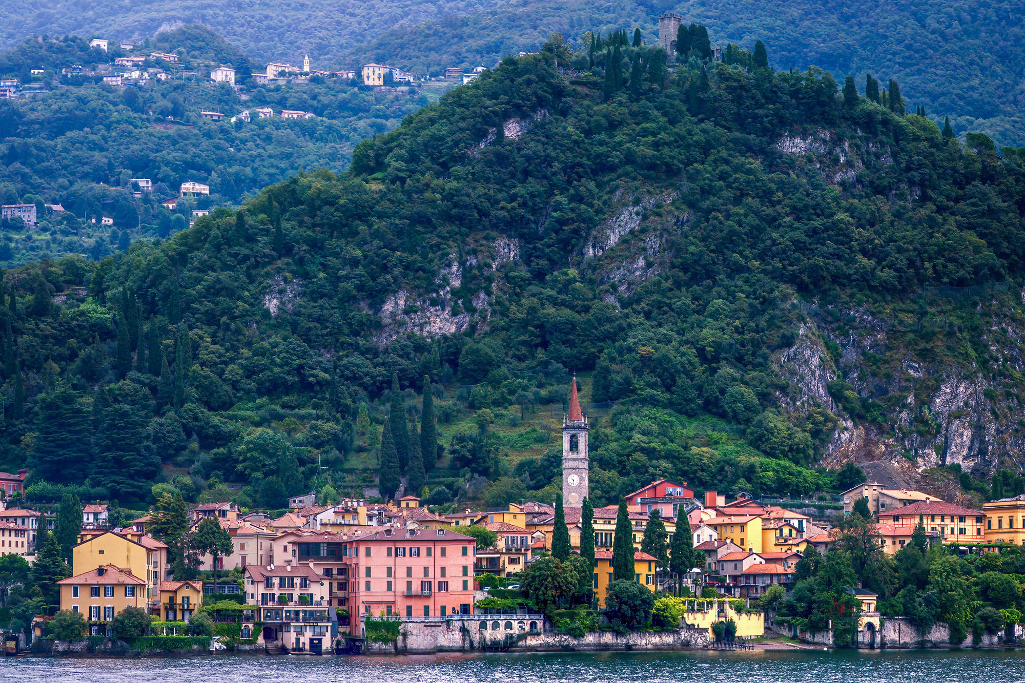 Varenna's Mountain Majesty This photograph, captured from Lake Como in Varenna, Italy, beautifully frames the charming village nestled at the foot of a...