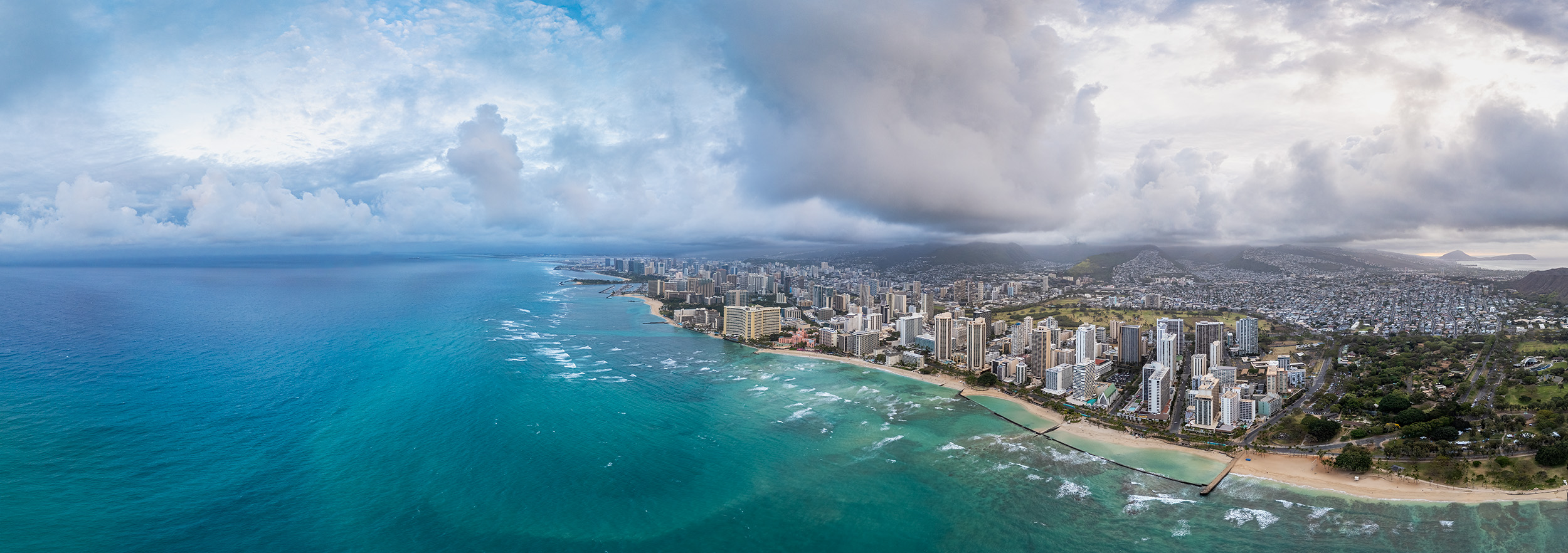 Waikiki Horizon: A Panoramic Vista Captured from a soaring drone perspective, 'Waikiki Horizon' offers a breathtaking panorama of the iconic Waikiki Beach. Crystal...