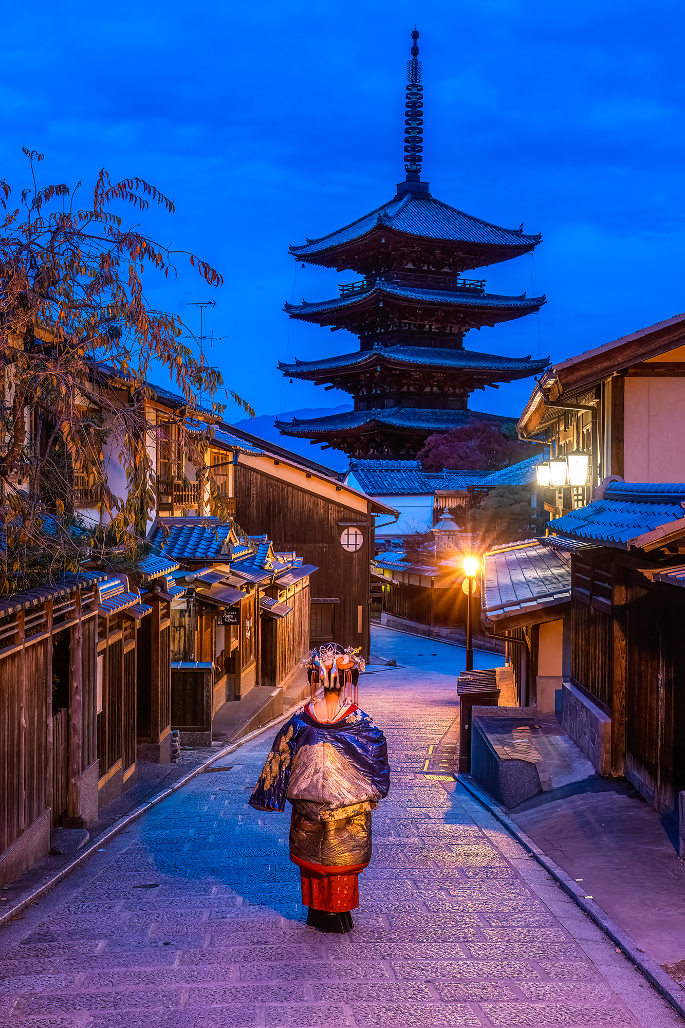 Elegance in Twilight: Geisha Grace at Hokan-ji In this enchanting image, we glimpse the world of Kyoto's geisha as twilight falls over the historic Hokan-ji Temple area. A...