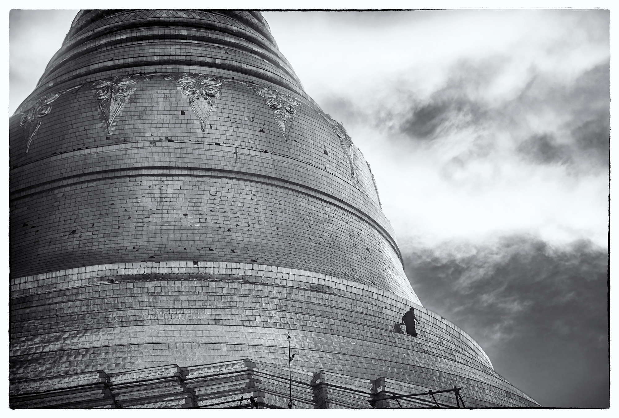 In this monochromatic image, a monk walks along the edge of the grand Shewadago Pagoda in Yangon, Myanmar. The sheer enormity...