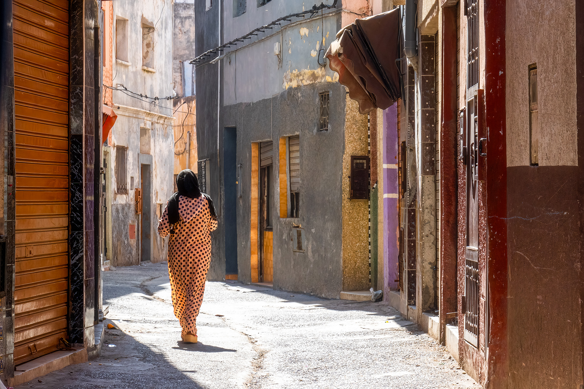 Colors of the Medina As I wandered the narrow streets of El Jadida, Morocco, I captured this evocative image. It portrays a Muslim woman, her attire...