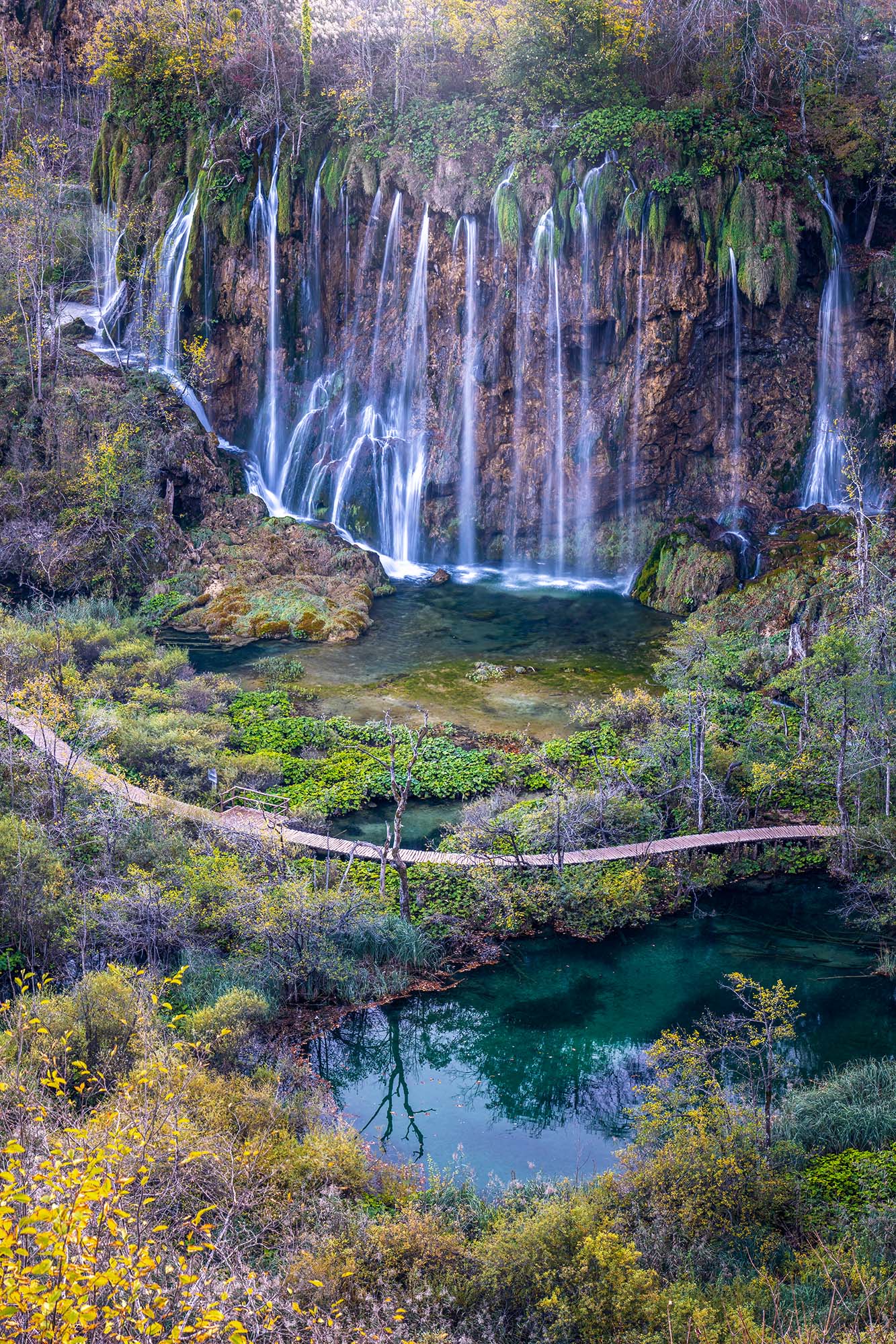 "Autumnal Cascades" presents a vertical snapshot captured during the vibrant fall season in Plitvice National Park, Croatia....