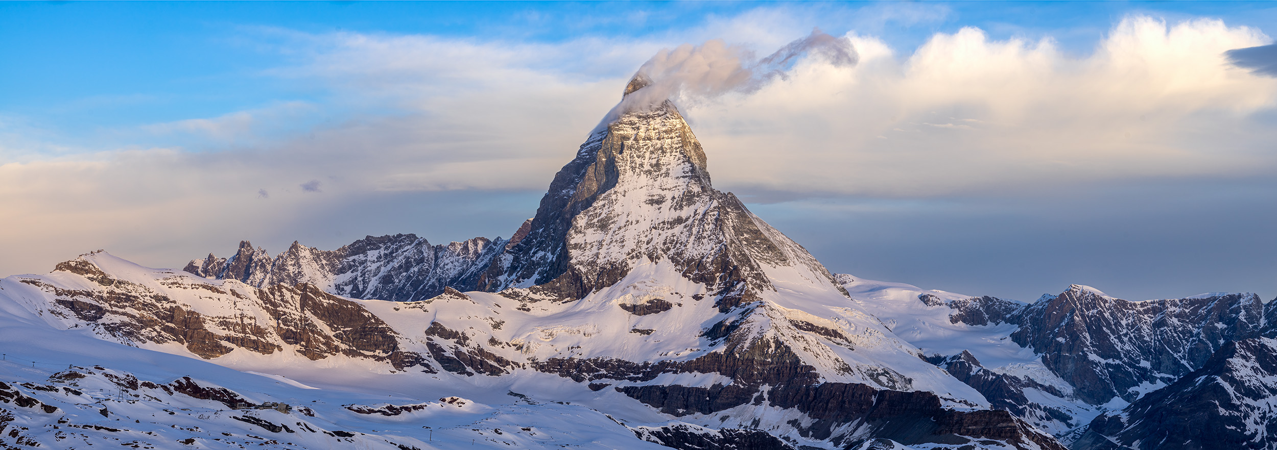 In "Horizon's Embrace," the Matterhorn's iconic silhouette emerges against a canvas of snow and rock, gracefully converging with...
