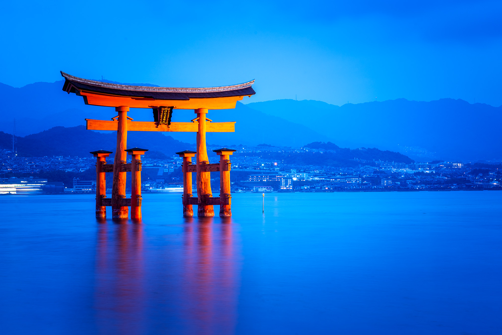 This mesmerizing image captures the serene beauty of the Itsukushima Jinja Otorii during blue hour. The vibrant vermillion of...
