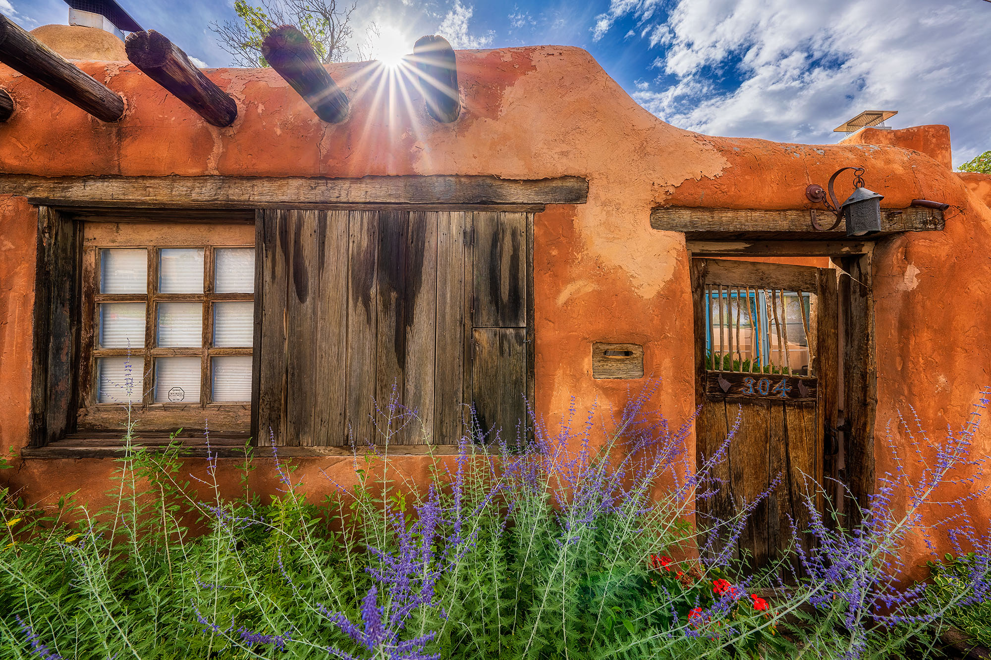"Adobe Radiance" captures the essence of Santa Fe's historic art district. This image showcases an aged adobe home with rustic...