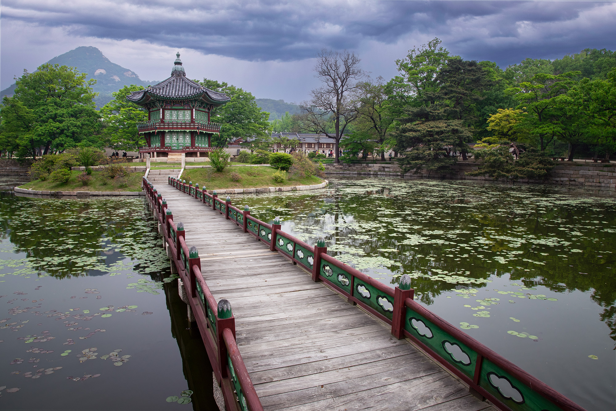 This image captures the enchanting Hyangwonjeong Pavilion in South Korea. The path begins at the bottom, guiding us through a...