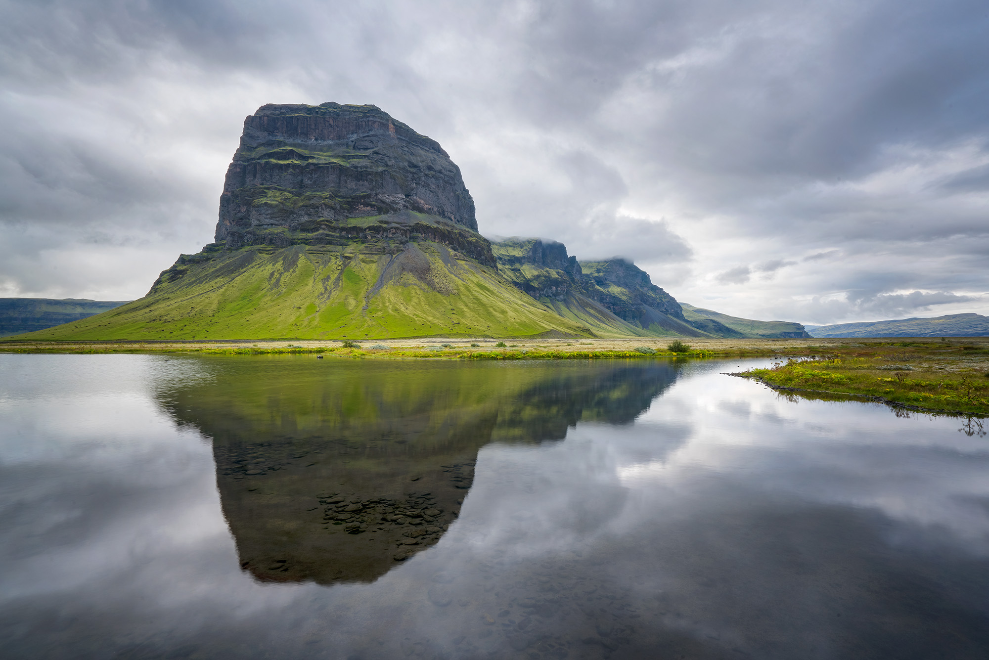 This striking image showcases Lómagnúpur, an iconic mountain in Iceland, mirrored perfectly in a tranquil reflection. Lómagn...