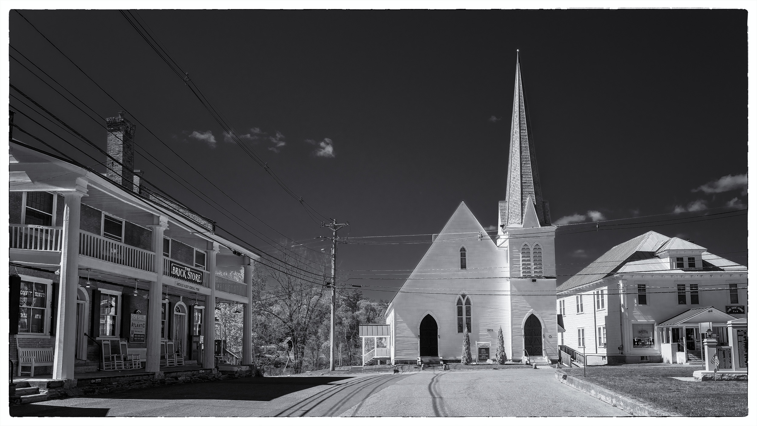 This panoramic view of Bath, New Hampshire, captured in black and white, evokes a sense of enduring tradition. Dominating the...