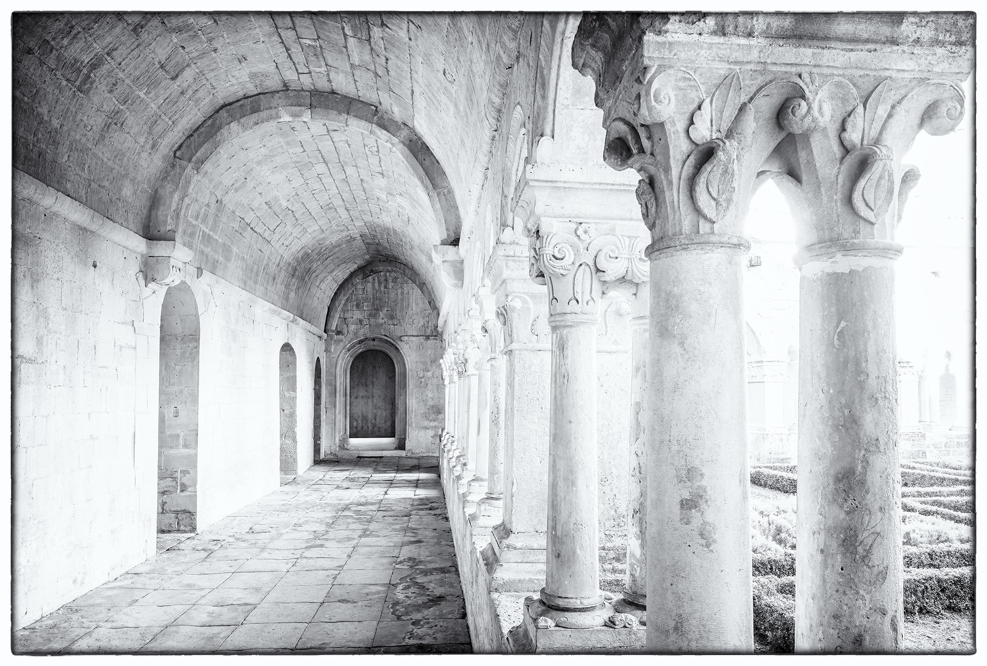 Courtyard Corridor In this black and white image, shadows and contrast artfully guide the viewer down the corridor of the courtyard. The photograph...