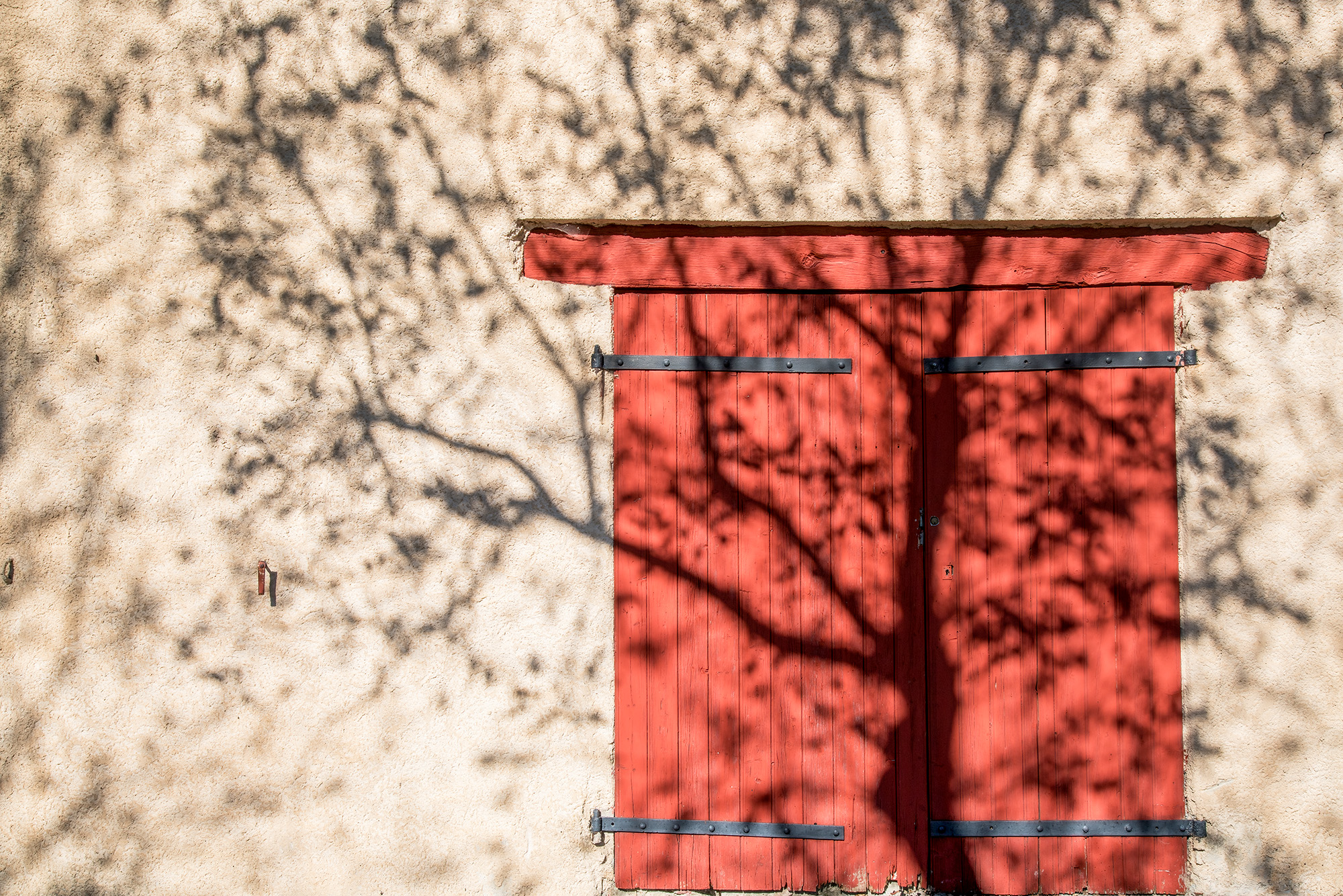 Early in the morning, I stumbled upon this powerful image in Moustiers Ste Marie, France. A red door and a brilliant tree shadow...
