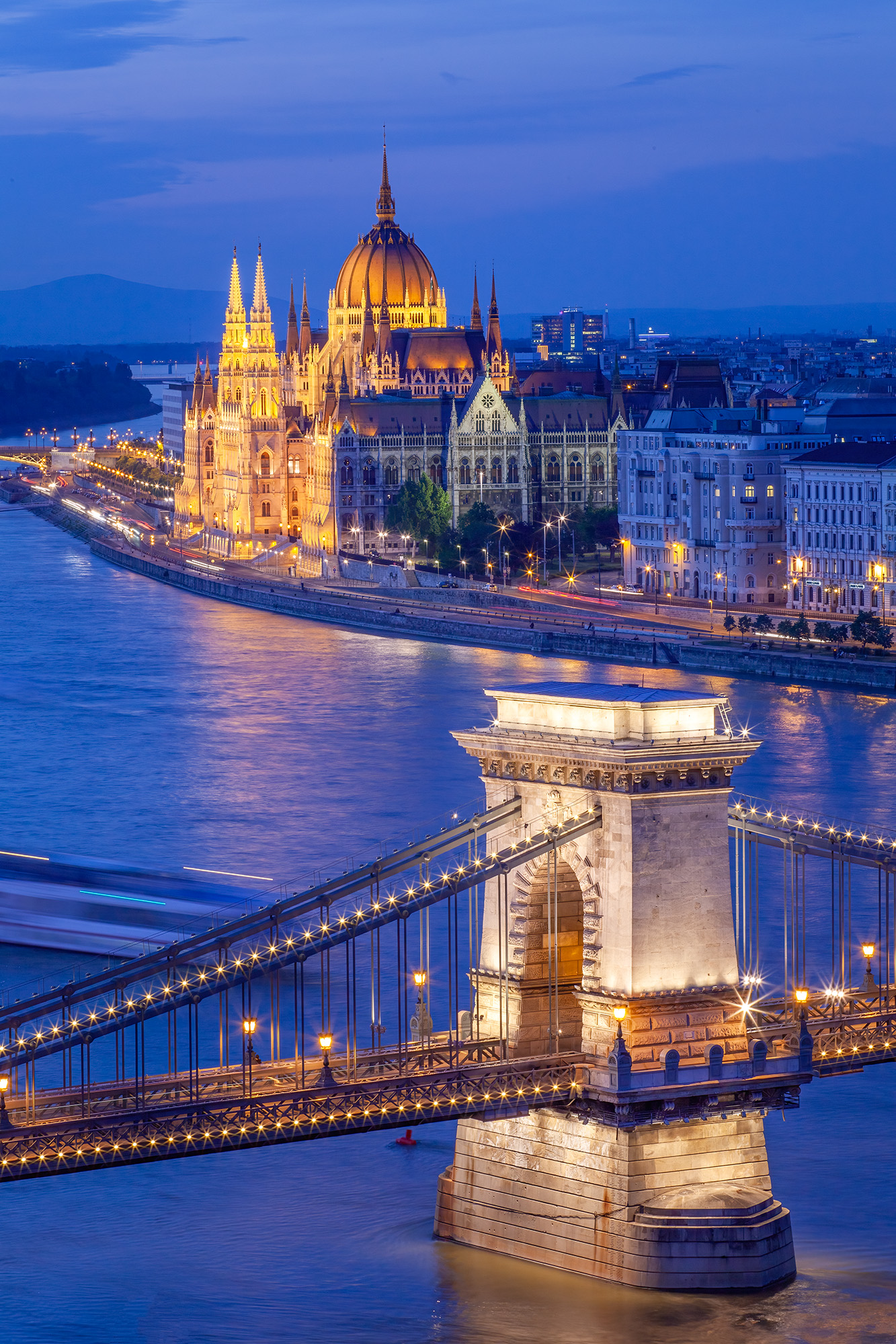 Budapest's Chain Bridge and Parliament During the blue hour, this vertical image unveils Budapest, Hungary's iconic Chain Bridge gracefully connecting with the majestic...