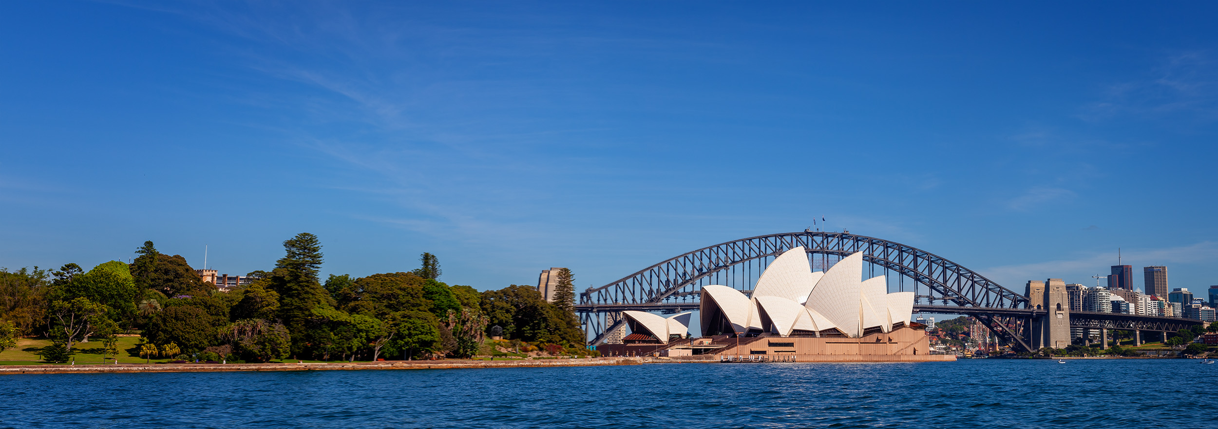 This panoramic image showcases two of Sydney's most iconic landmarks – the Sydney Opera House and the Sydney Harbour Bridge...