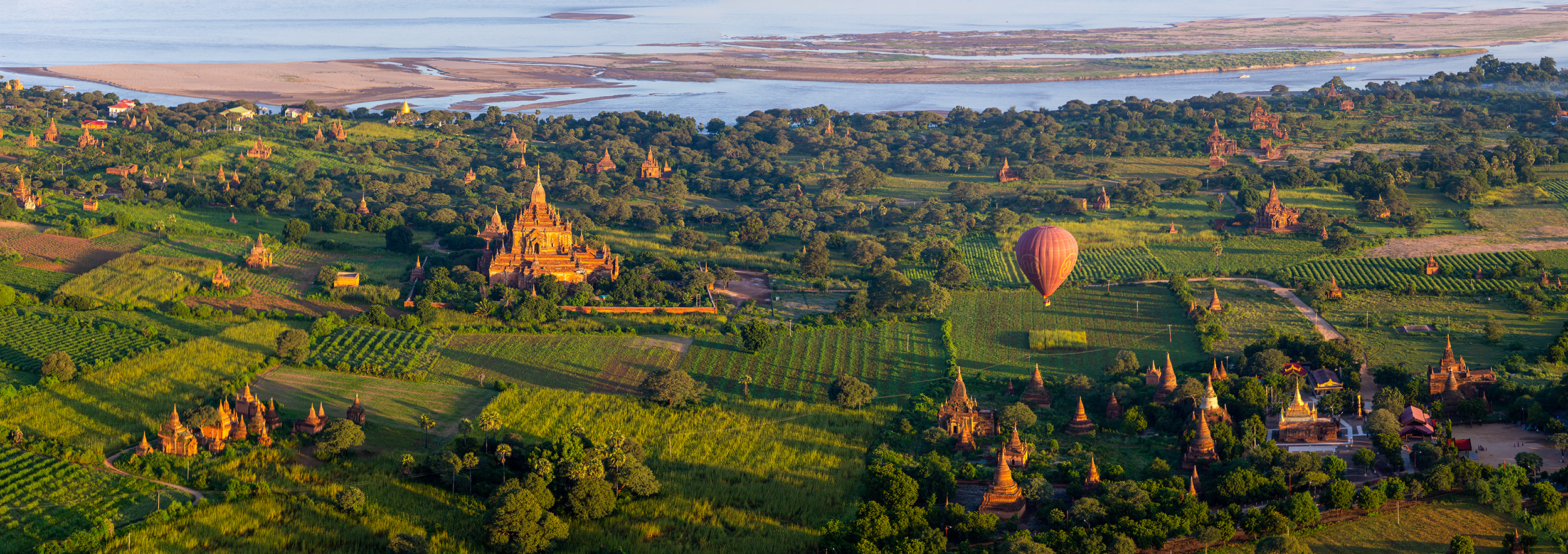 Captured from high above in a hot air balloon, "Bagan's Rooftops" offers a mesmerizing panoramic view of the ancient temples...