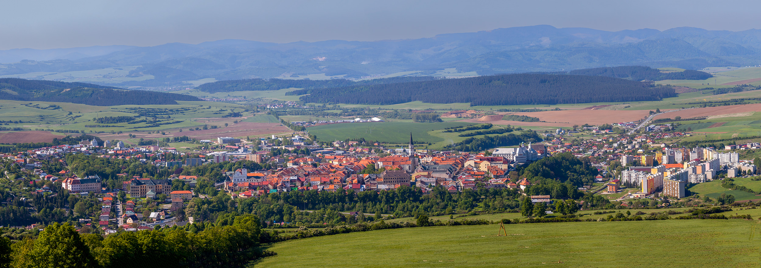 Levoca's Timeless Landscape This panoramic view of Levoca, Slovakia, showcases the town's charming red-tiled rooftops nestled within the surrounding countryside...