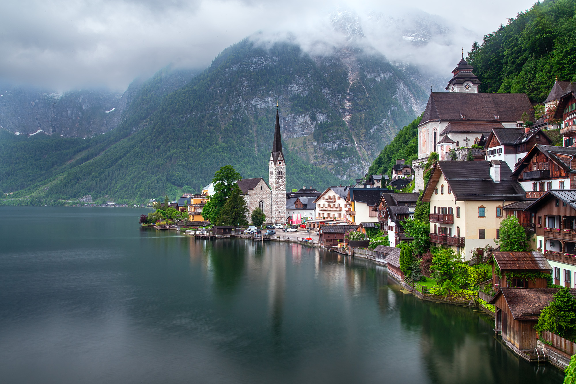 On a drizzly day in the picturesque village of Hallstatt, Austria, this image captures the essence of its enduring charm. The...