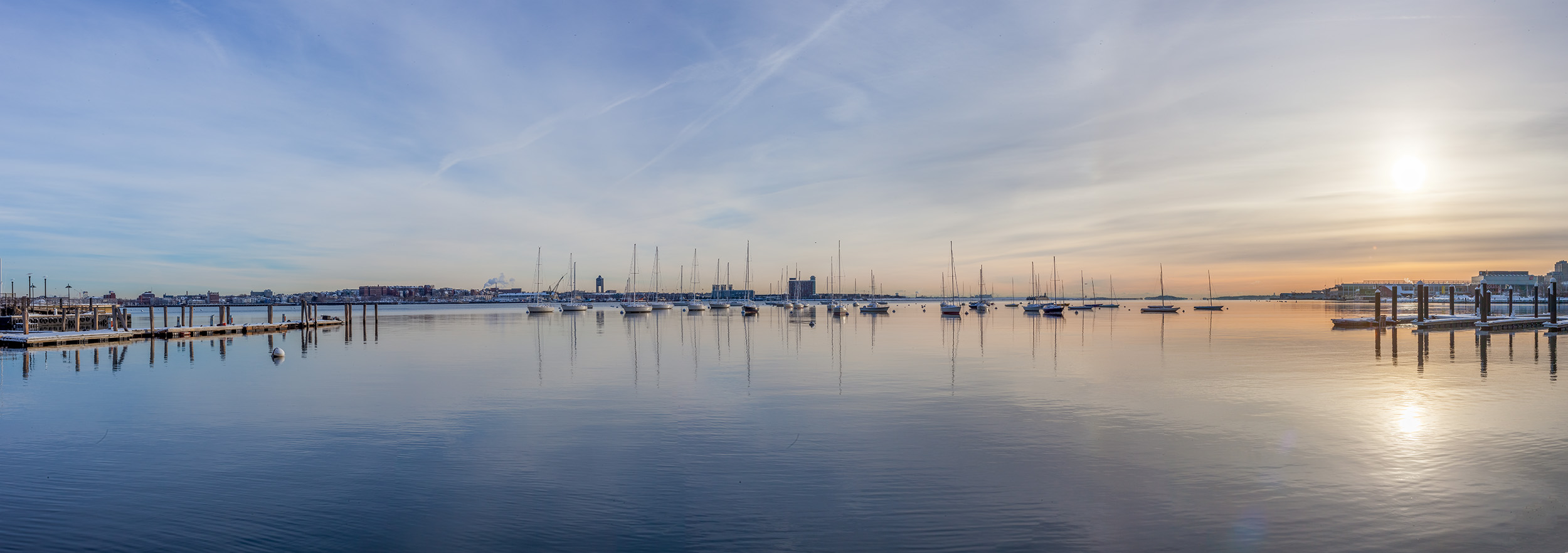 In the icy grip of a 5°F morning in Boston, Massachusetts, I captured this panoramic photograph of the harbor. As the sun rose...