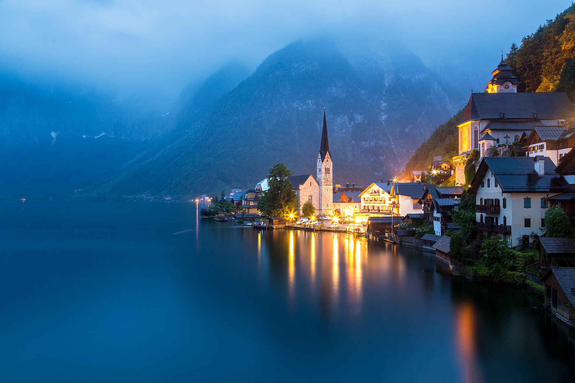 Halstatt in Blue Hour Photography often demands dedication, even in adverse weather. In the midst of a downpour, I stood determined, shielding my camera...