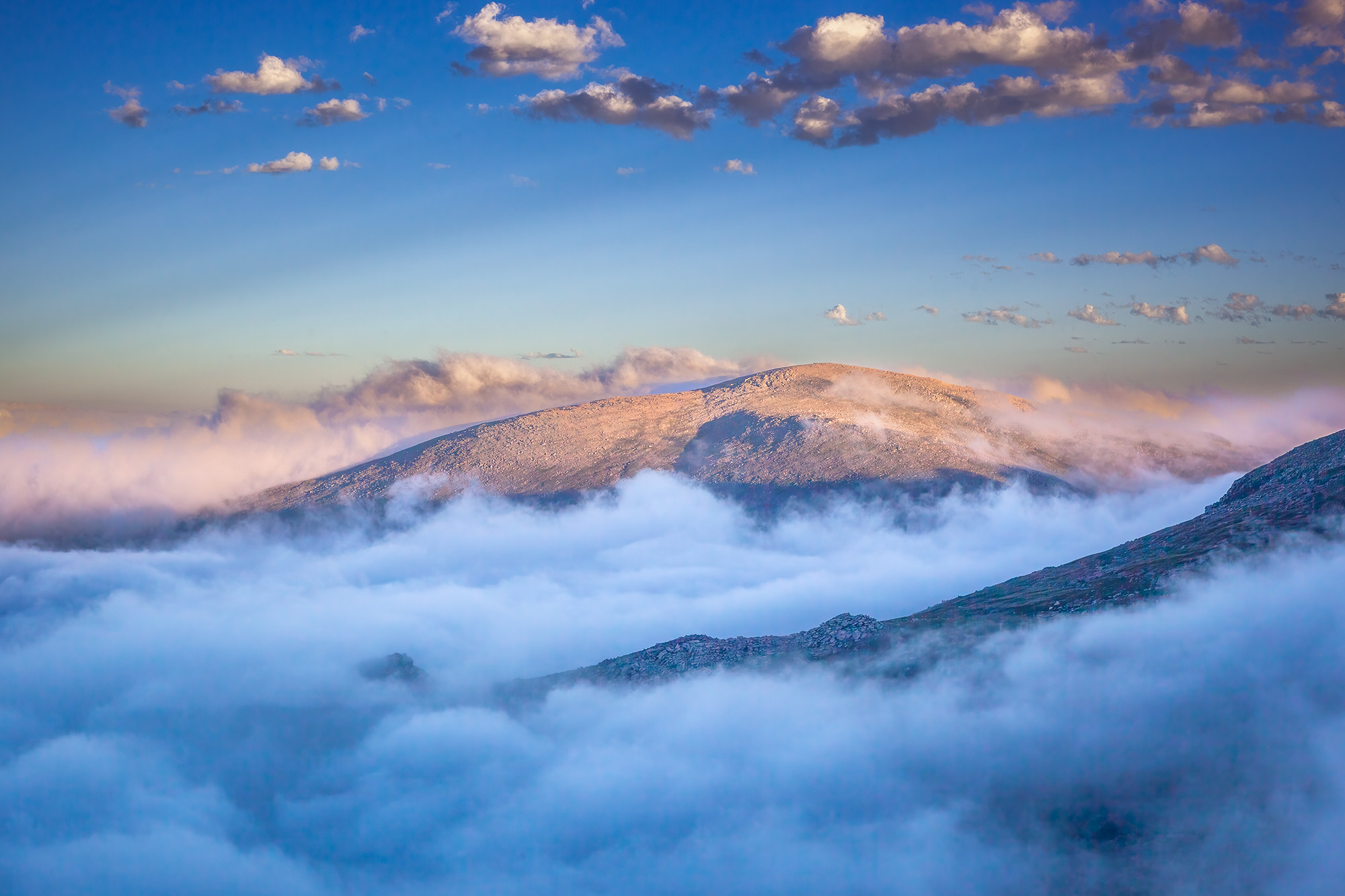 This image, captured from the summit of Mount Evans in Colorado, reveals a breathtaking perspective. Here, we soar above the...