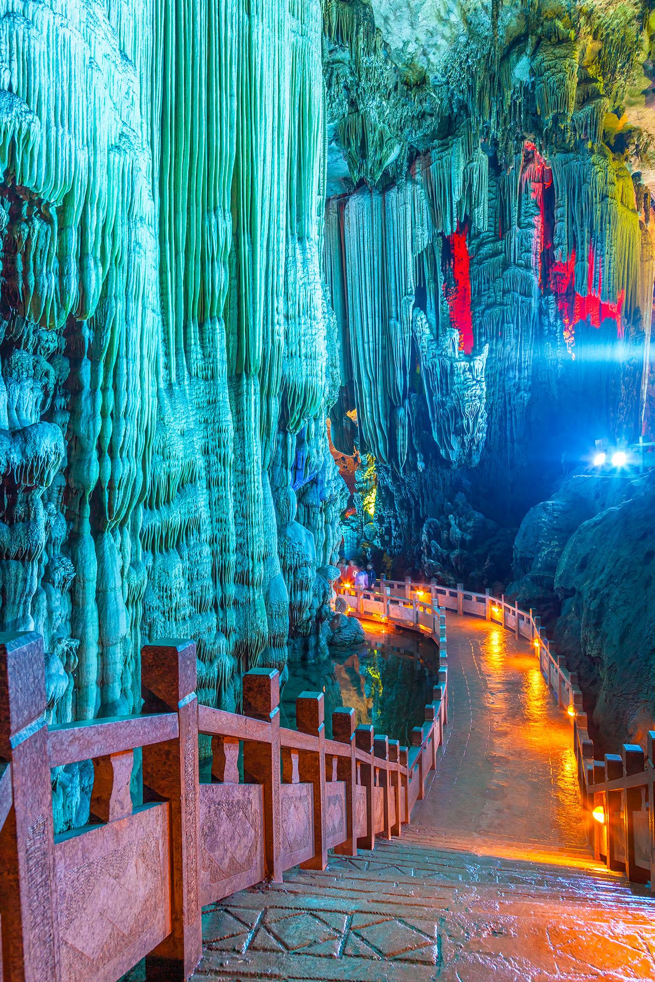 Inside China's Reed Flute Cave, my path led deeper into the subterranean realm. The photograph captures a striking display of...