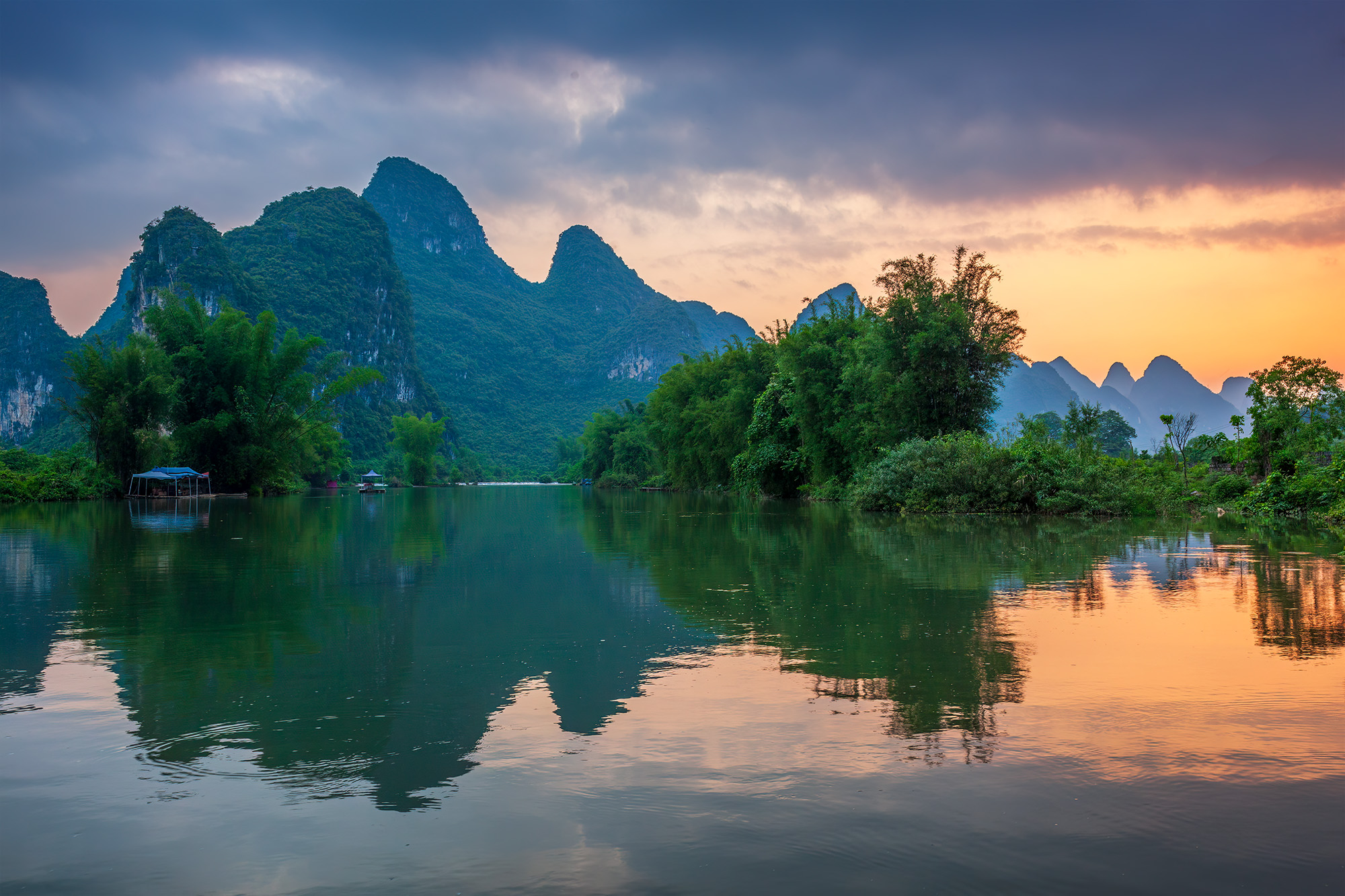 In this striking image from the Yulong River near Yangshuo, China, nature's grandeur unfolds as the karst mountains are mirrored...