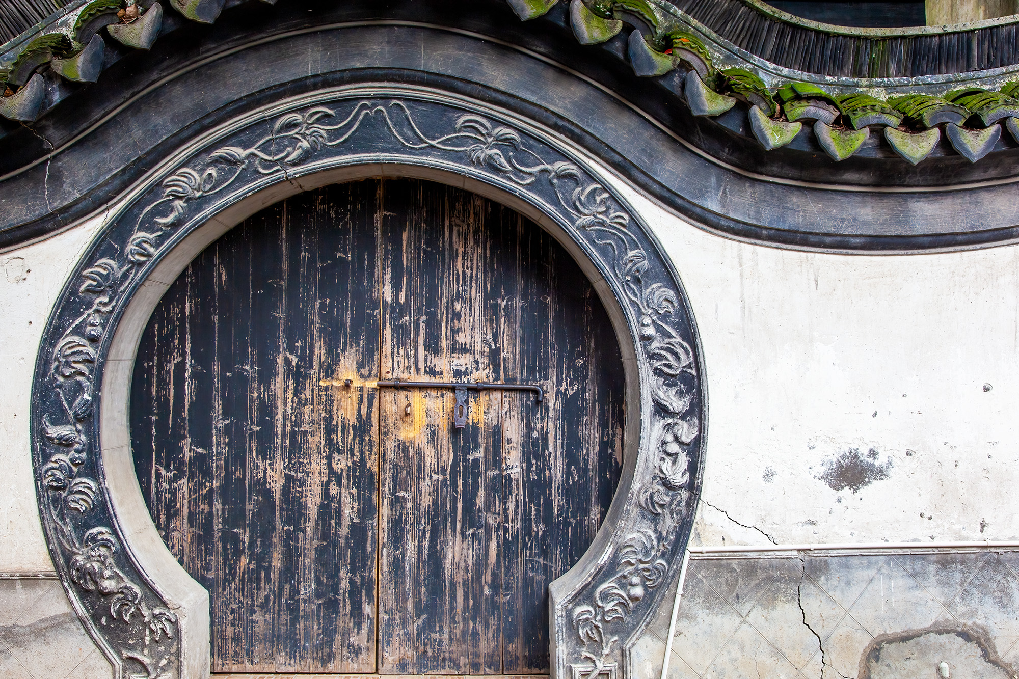 This snapshot captures the serene beauty of the Yu Yuan Gardens in Shanghai. The focal point is a circular door, its arched top...