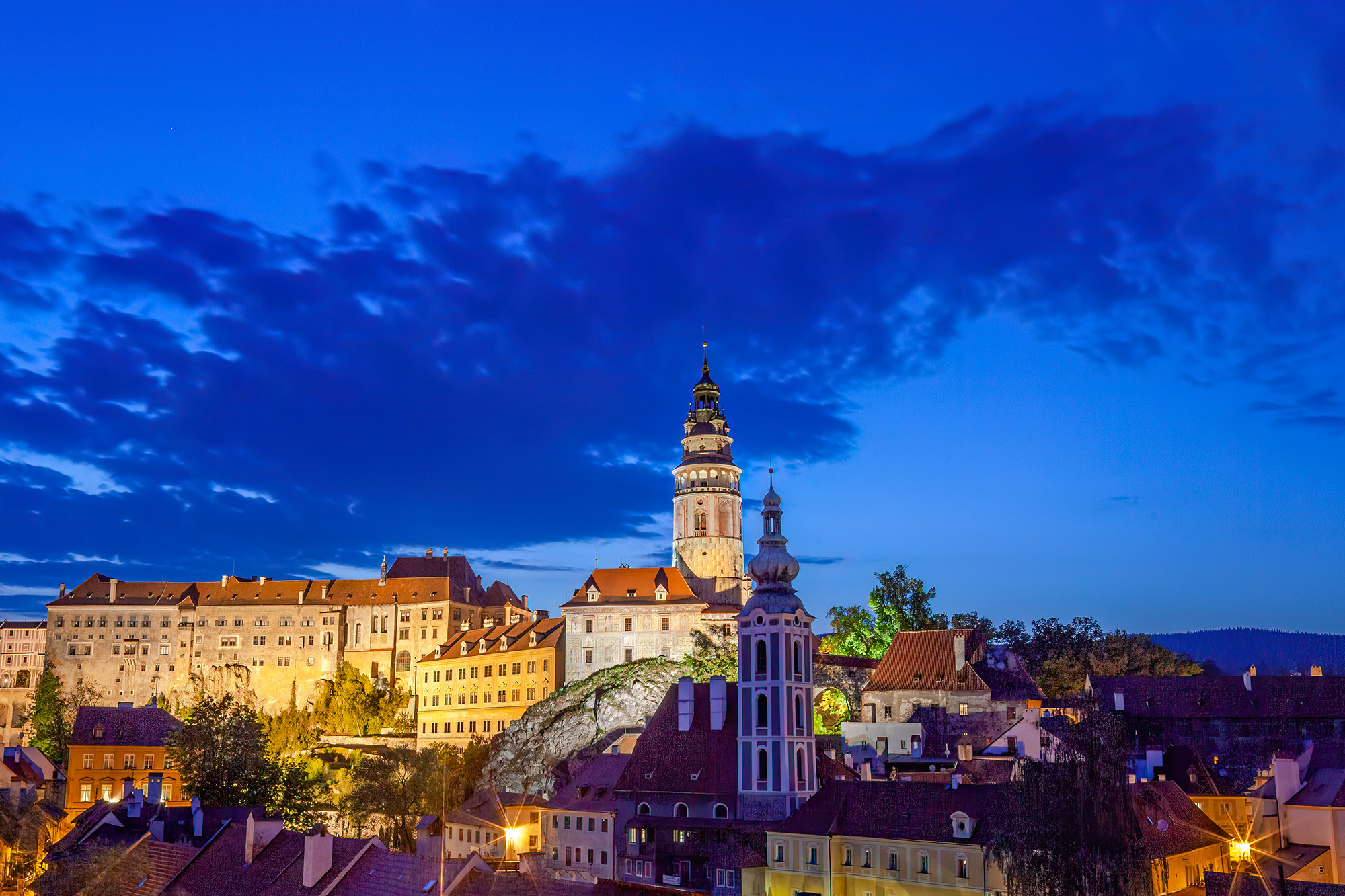 At the bewitching hour of twilight, the State Castle and Chateau of Český Krumlov, Czech Republic, assumes a regal aura. Illuminated...