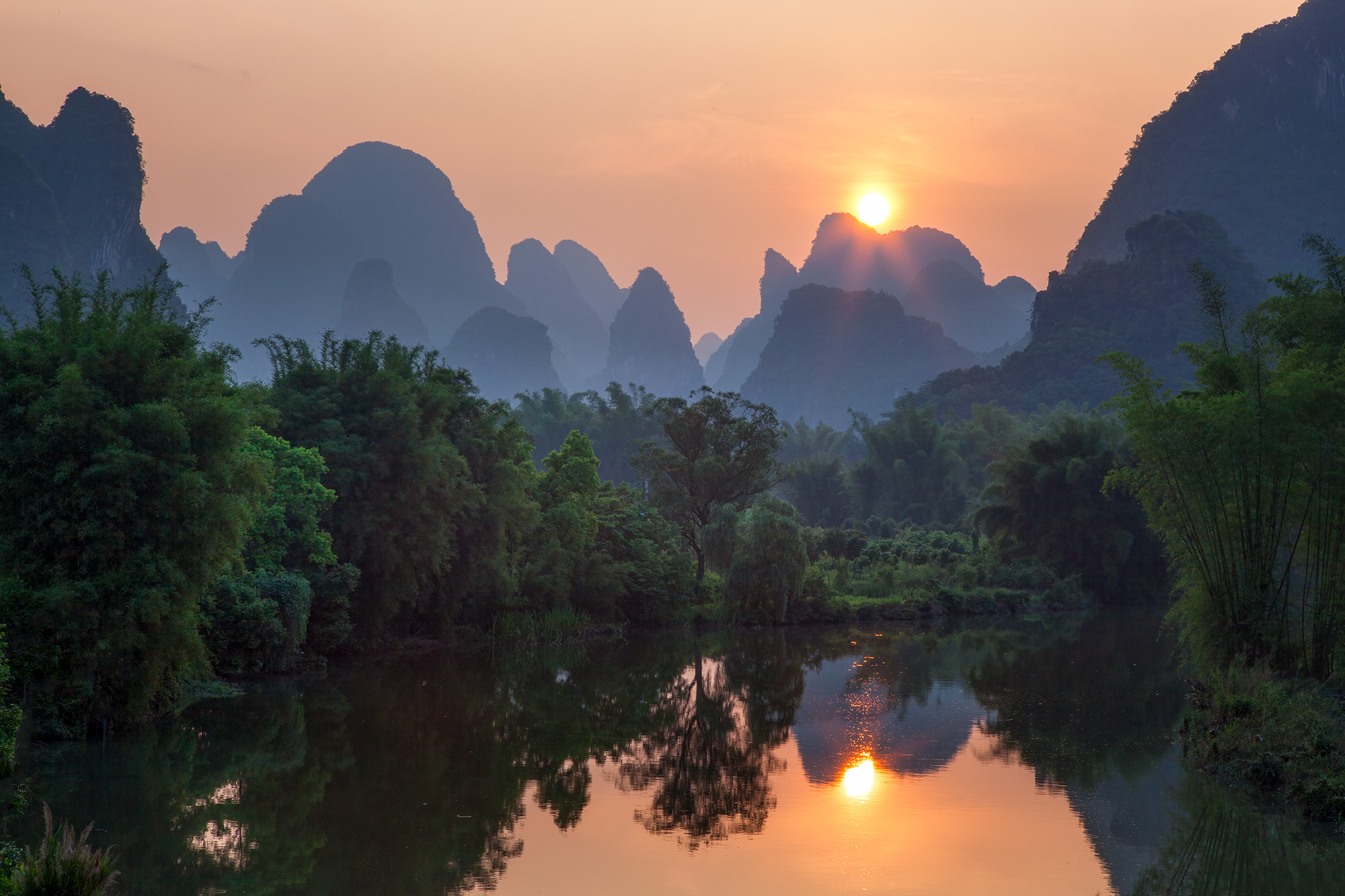 Lily and I scoured the Yangshuo area for the perfect sunset spot, the hot, humid air embracing us. As we ventured along the river...