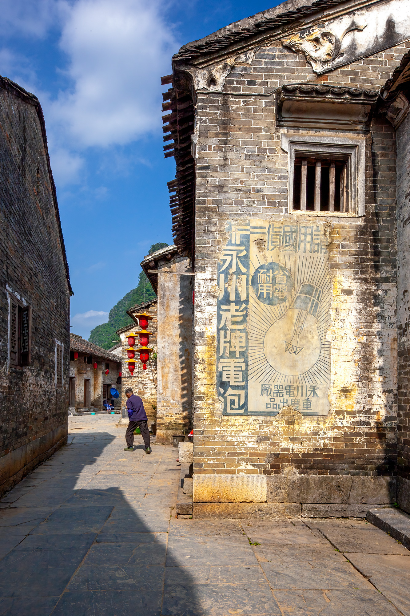 In the ancient town of Huangyao, Guangxi, China, my lens captured this vertical slice of history. Millennia-old buildings stand...