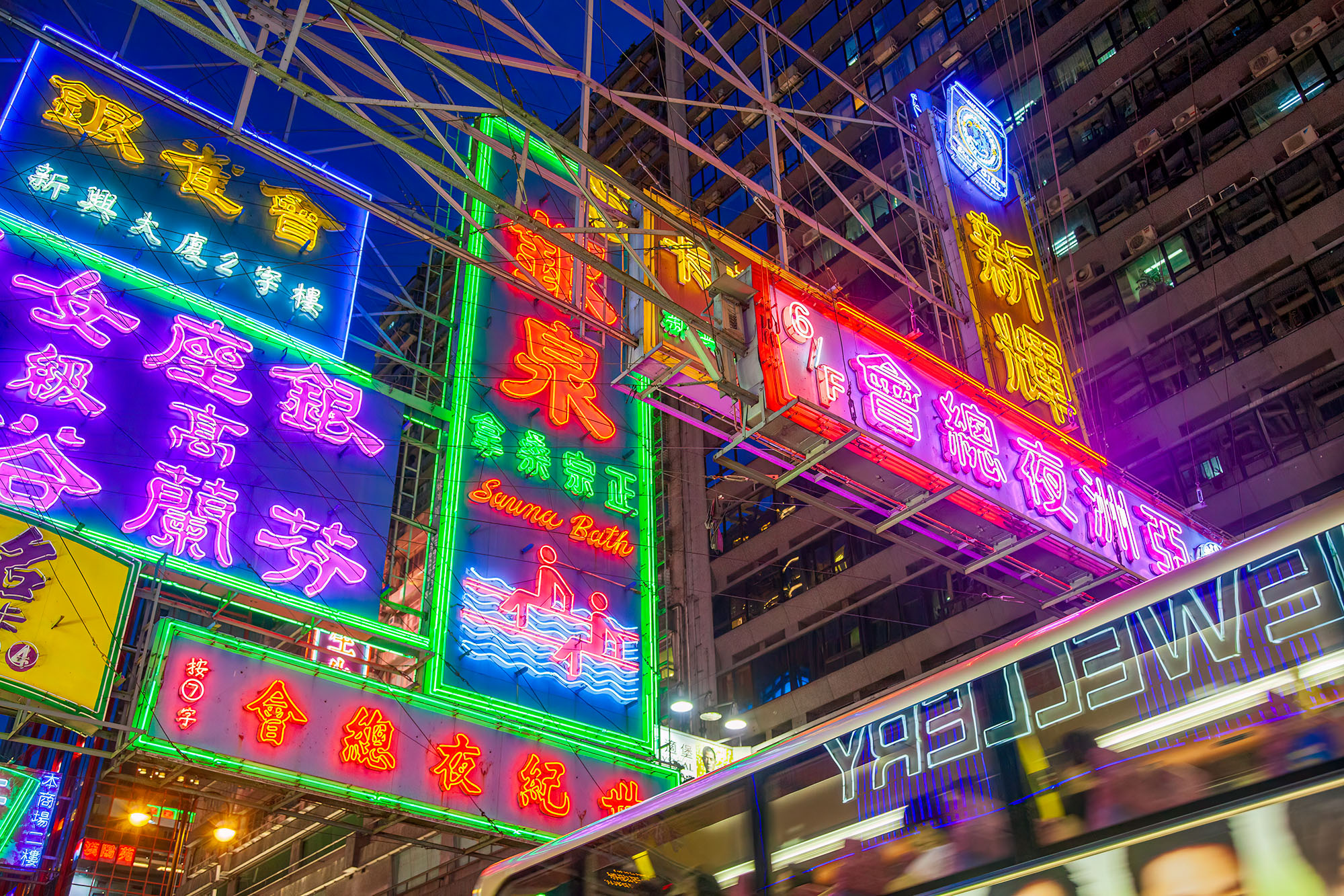 In the bustling streets of Hong Kong, this photograph captures a mesmerizing sight. Neon signs, adorned with vibrant Chinese...