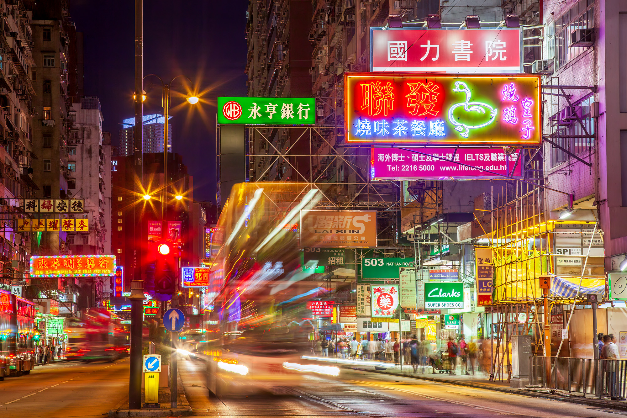 Nathan Road Nightscape This photograph captures the bustling spirit of Nathan Road in Kowloon, Hong Kong, a bustling thoroughfare renowned for its vibrancy...