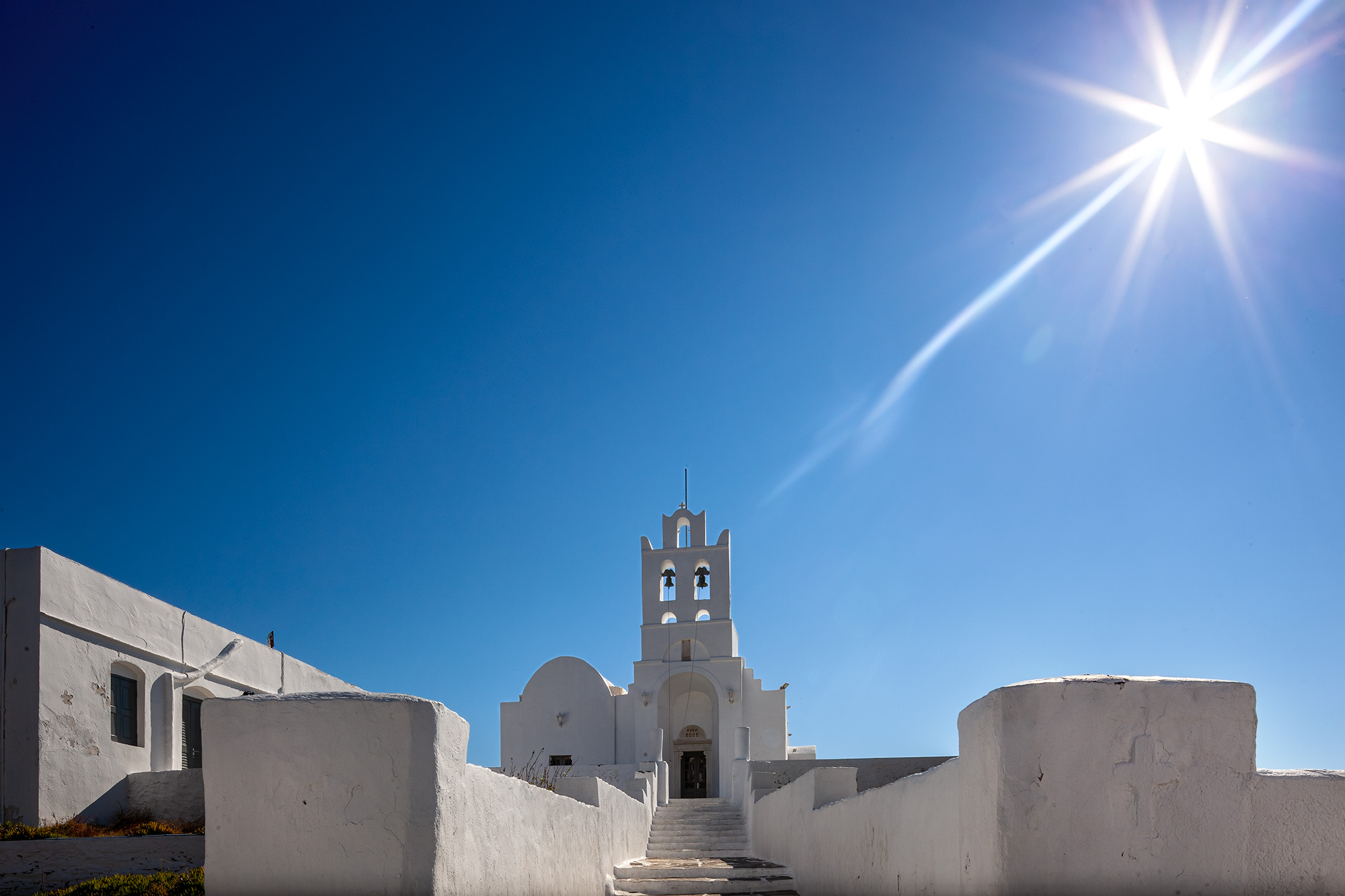 Amidst the serene ambiance of Chrysopigi Monastery on the idyllic island of Sifnos, Greece, this photograph captures a moment...