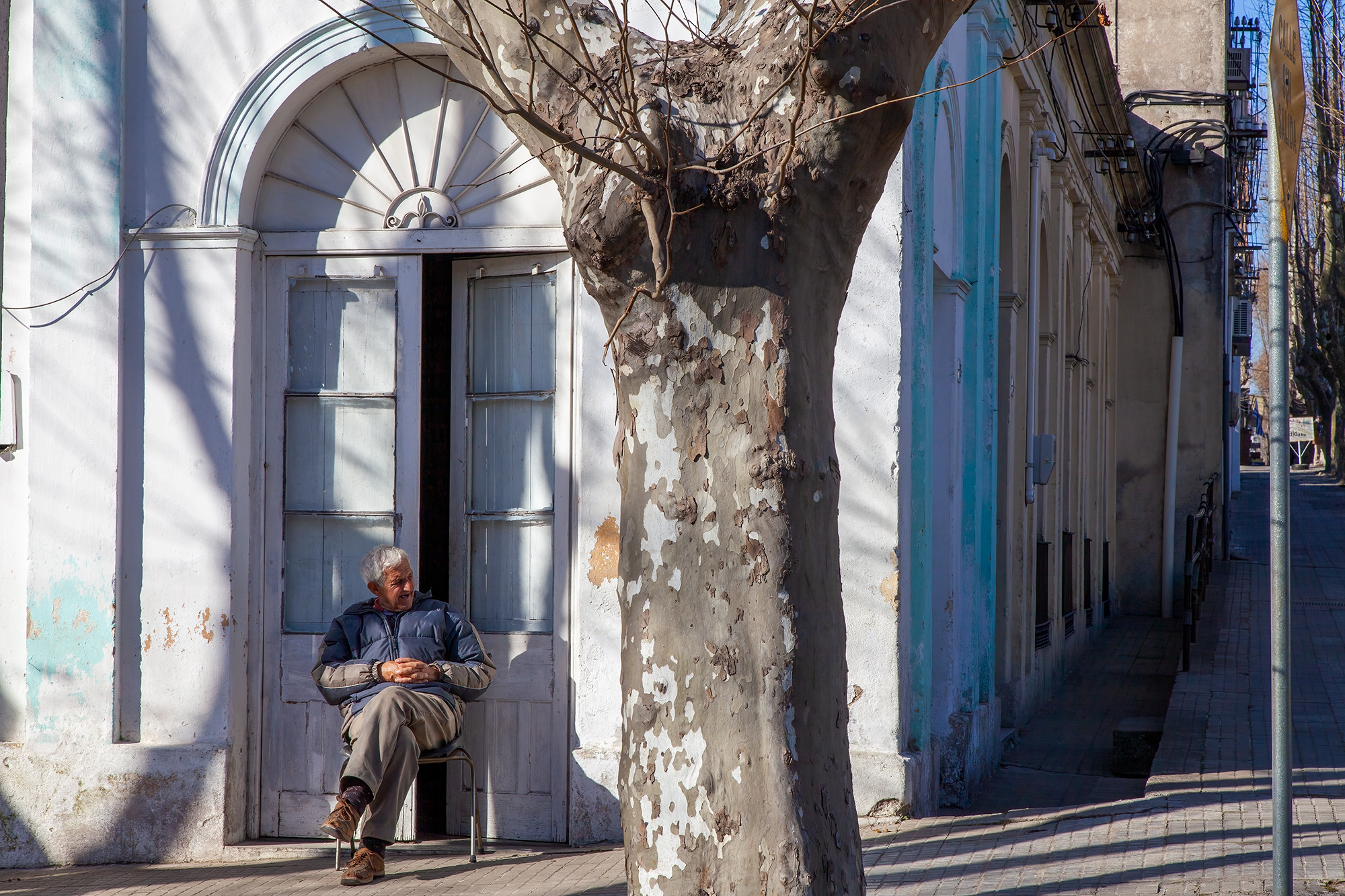 In the quaint streets of Colonia del Sacramento, Uruguay, a solitary figure finds solace in the warm embrace of sunlight. This...