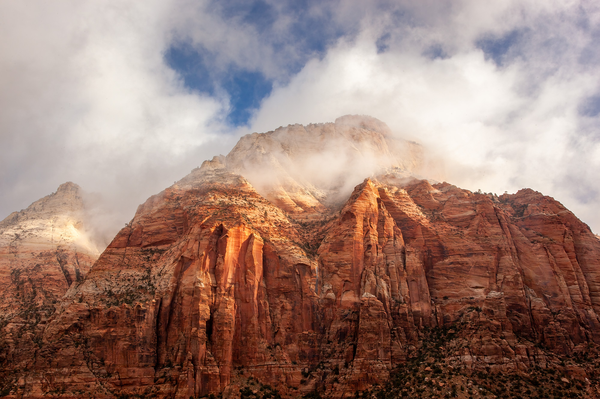 From the vantage of East Temple in Zion National Park, the sandstone walls take center stage, bathed in warm radiance. An enigmatic...