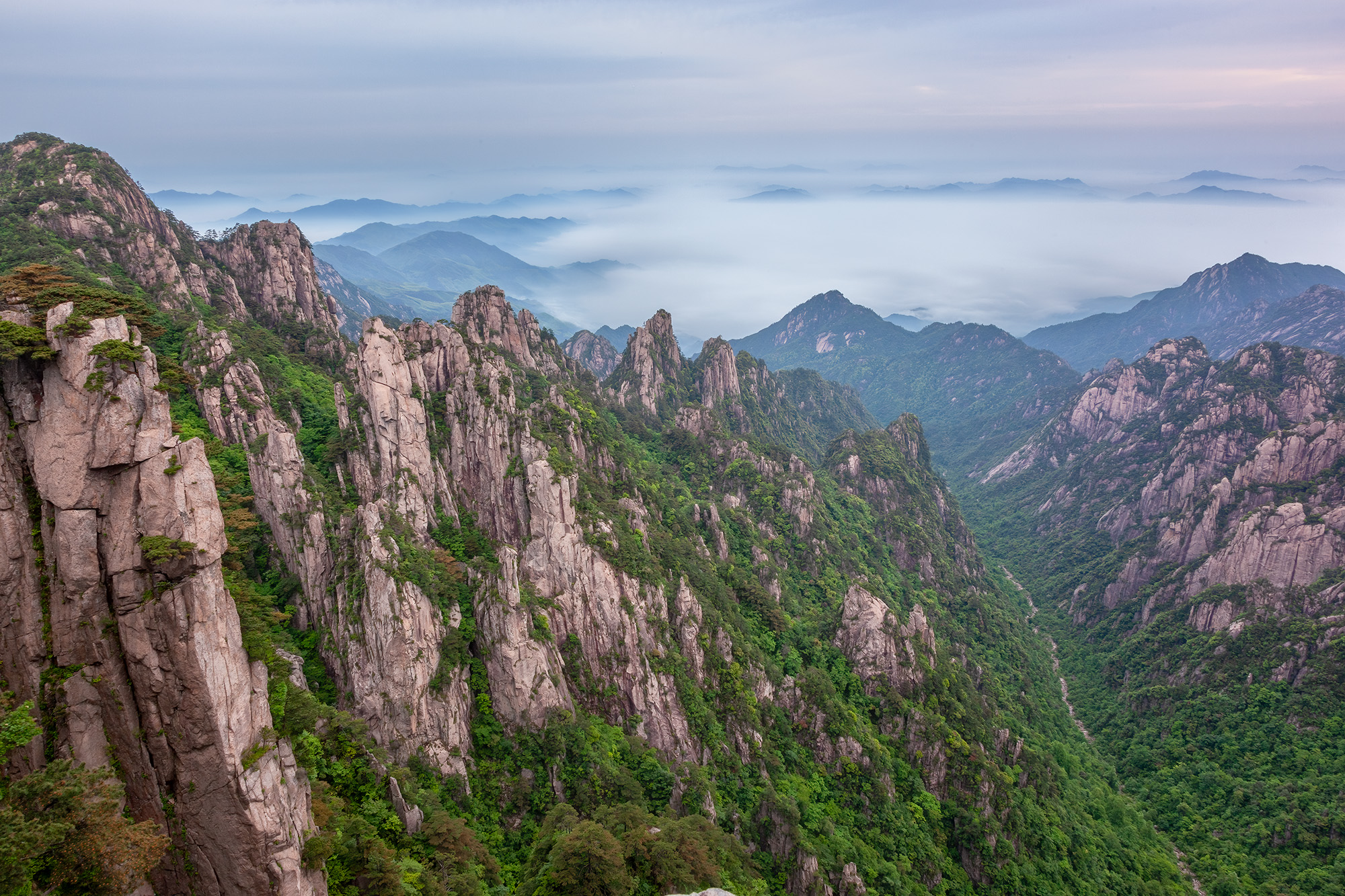 In this image from Mount Huangshan, China, we're presented with the signature landscapes of the region. Towering mountains adorned...