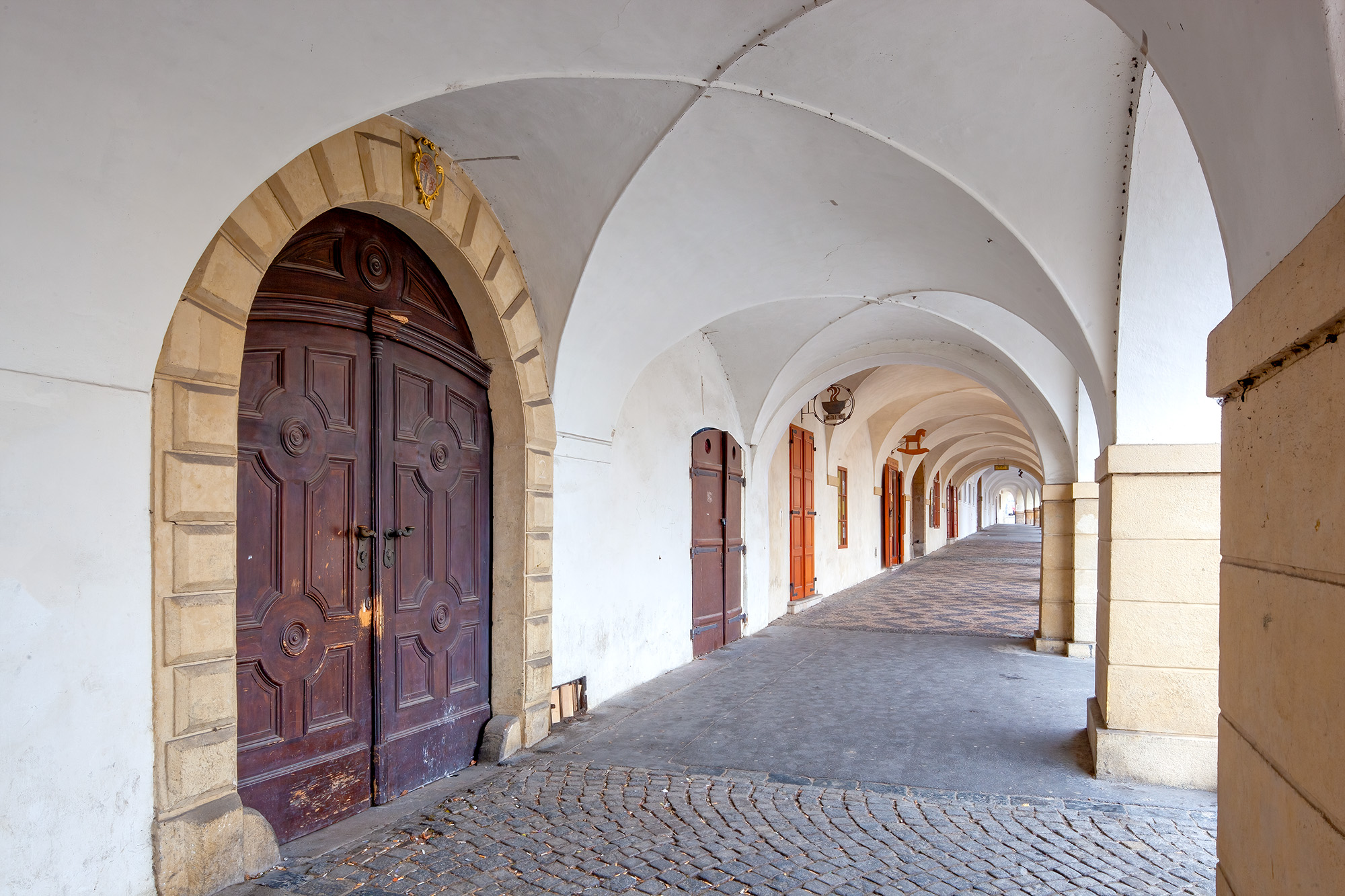 Elegance in Arches Captured within this image is the allure of a hallway adorned with a succession of graceful arches. Emerging from the center...