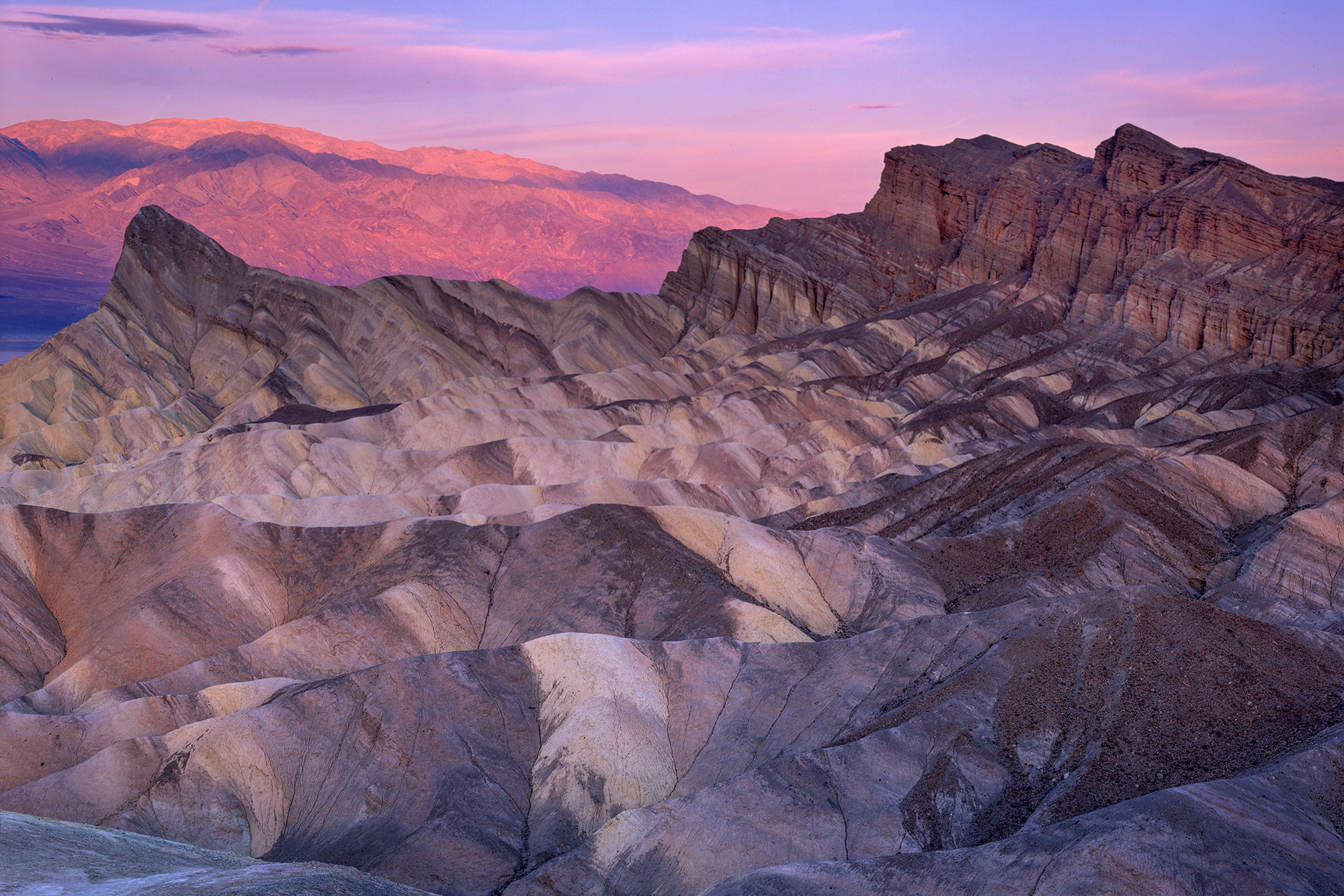 In this awe-inspiring image, captured at the break of day in Death Valley National Park, the striking beauty of Zabriskie Point...
