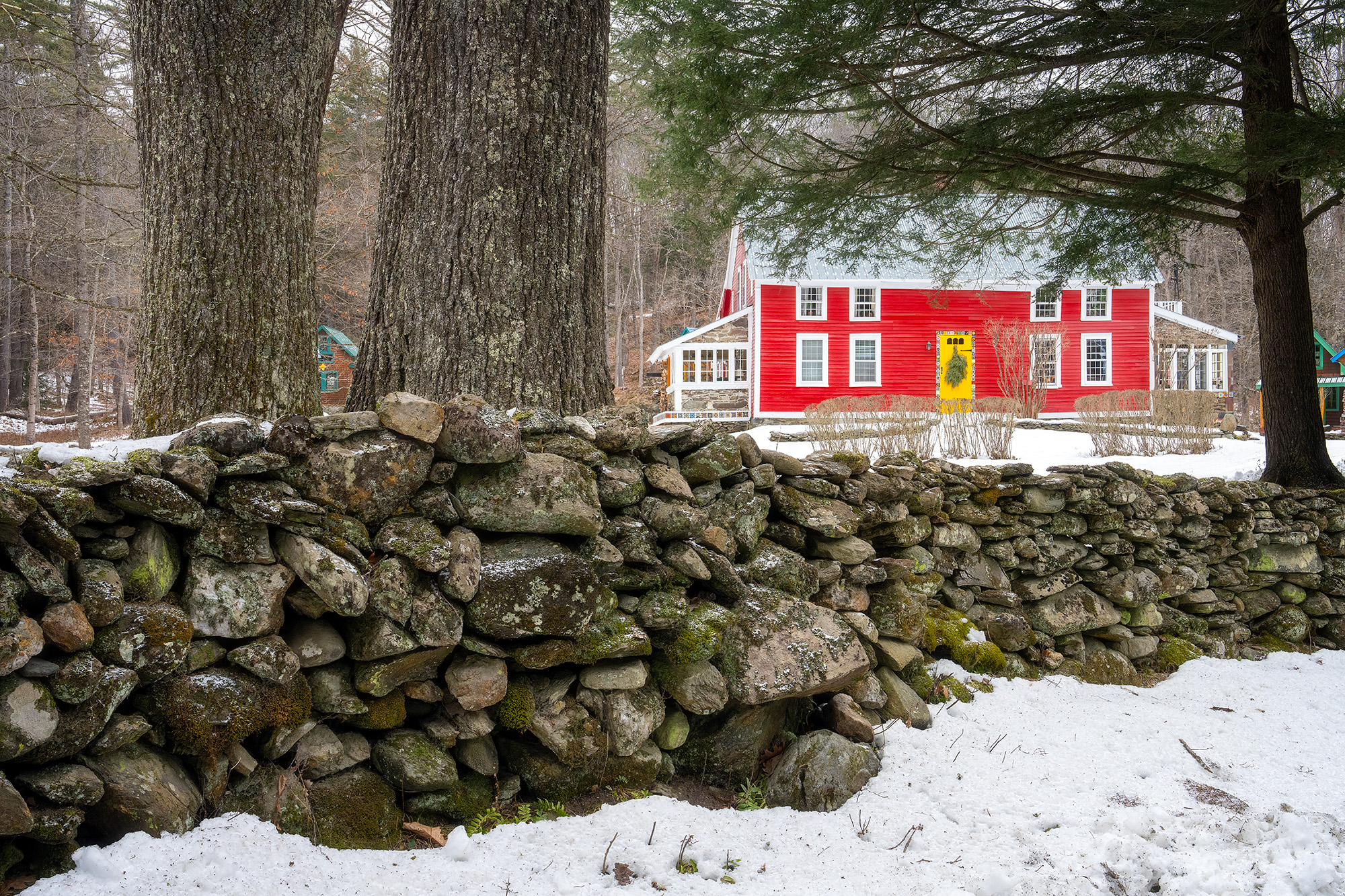 Winter's Embrace in Guilford Beyond a snow-draped stone fence and frost-laden trees, a red house stands quietly in the Vermont winter. The scene, captured...